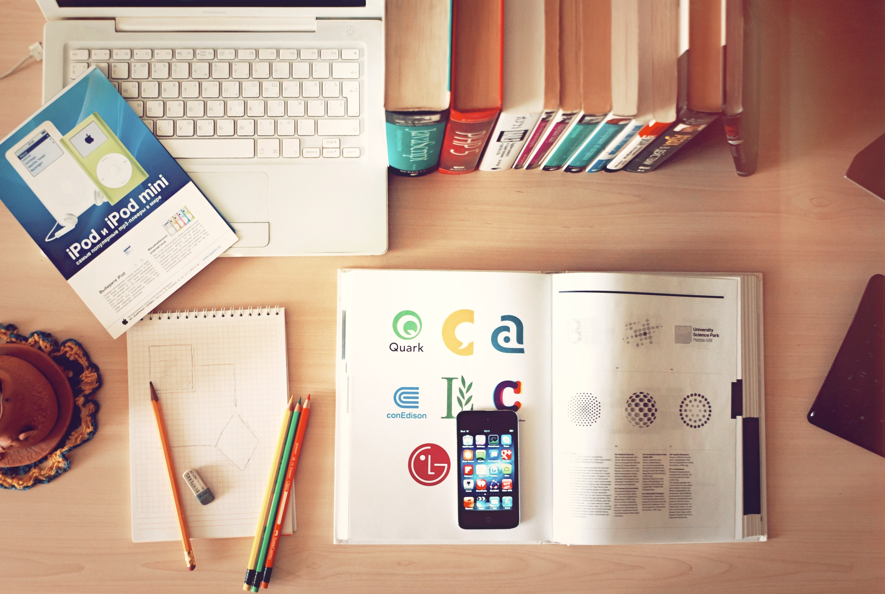 Real publishing desk with books, pencils, laptop, and phone